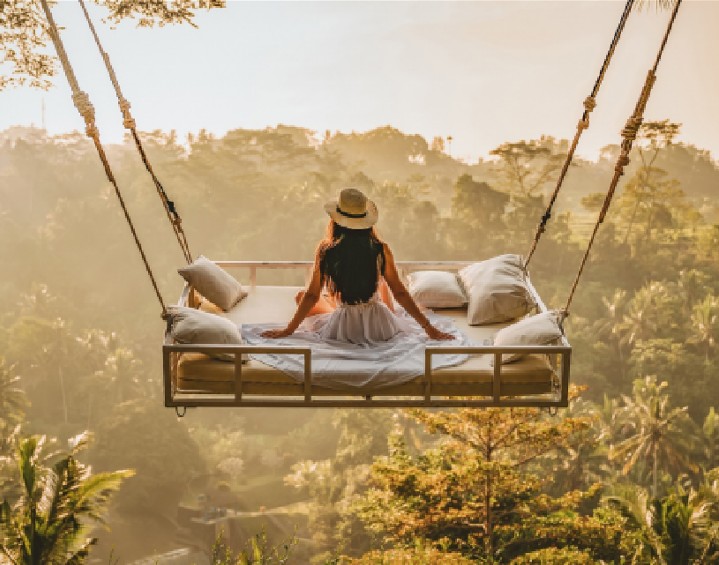 image of a women in large treetop swing