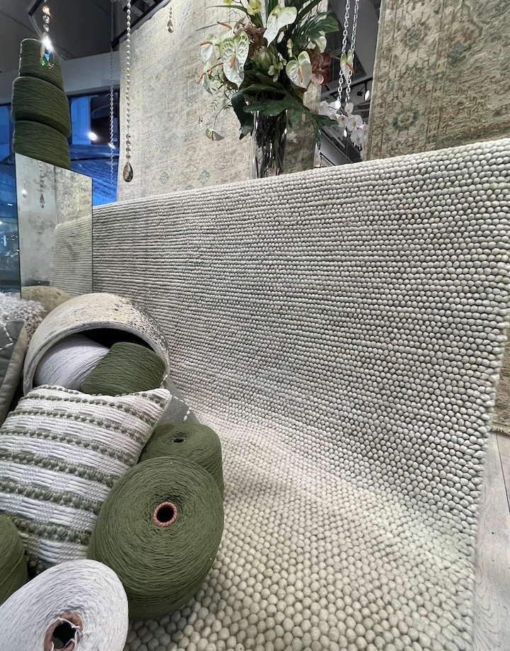 Nourison display of green toned rugs with new DKNY Pure Knots in sage