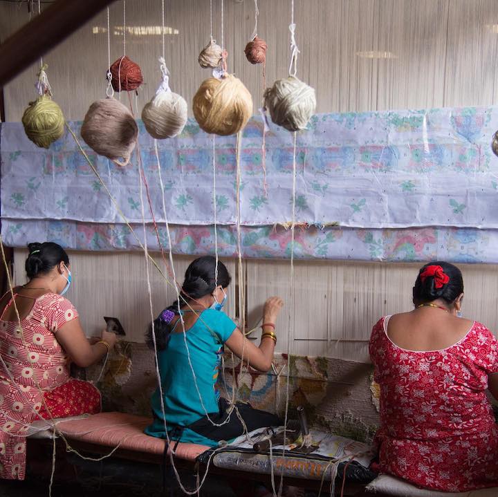 female weavers weaving carpet