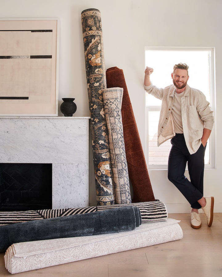 Celebrity designer Bobby Berk poses with his new rugs