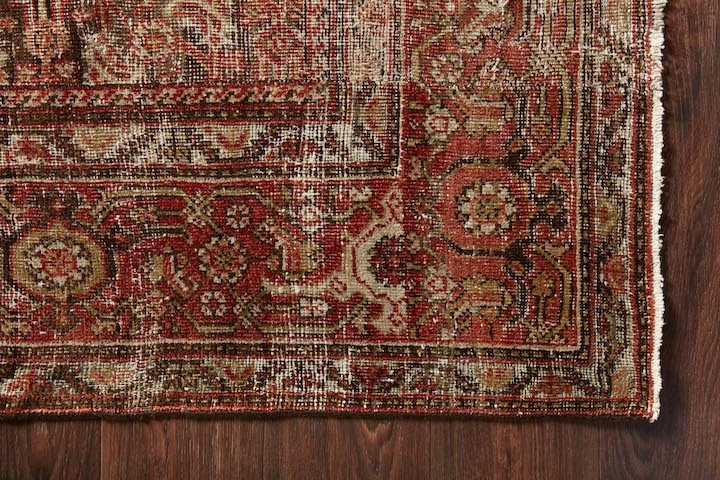 A shot of a rug corner with reds, creams, gold and brown