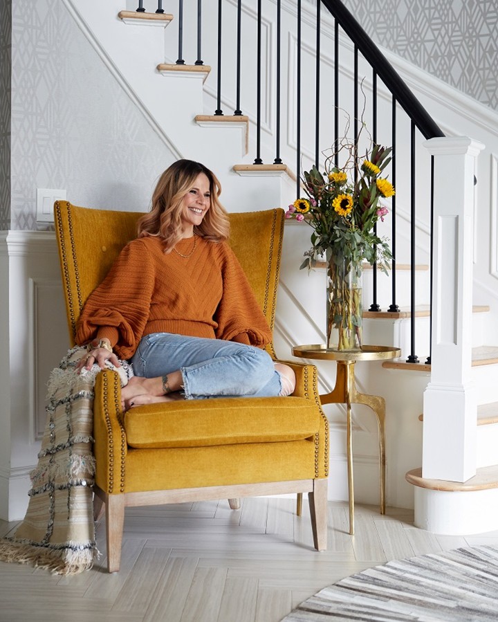 designer Stacy Garcia sitting in yellow wingback chair