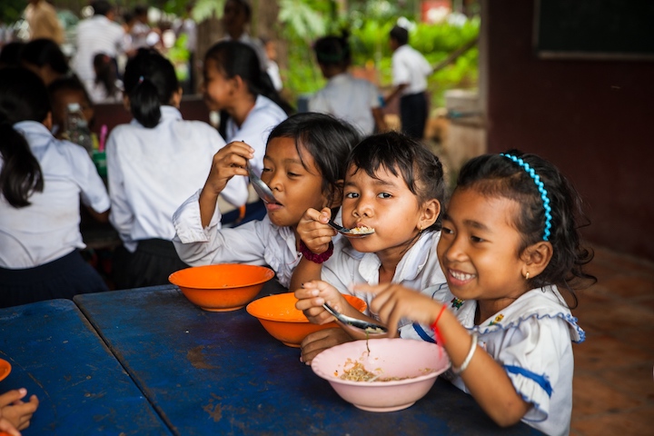 young Cambodian students eating school lunch