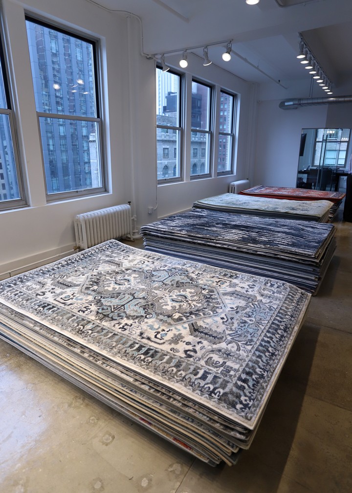 photo of stacks of rugs in NYC loft-like space with views of Manhattan