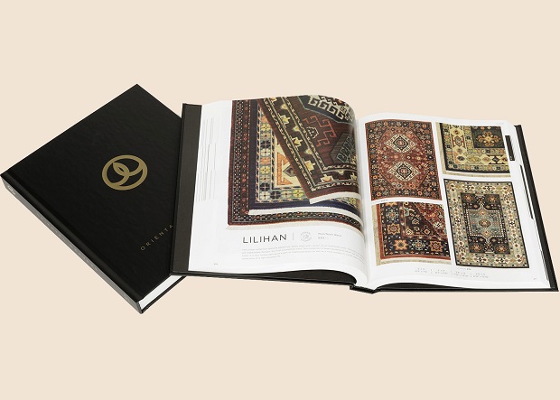 Two black covered books, one closed and one open to show images of rugs.