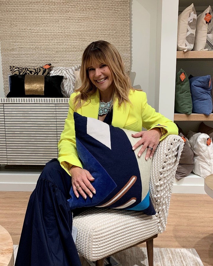 Stacy Garcia sitting in the LR home showroom with a new pillow design