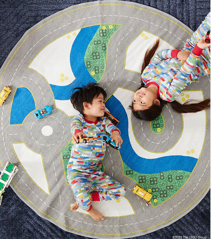 Two children laying on a play mat