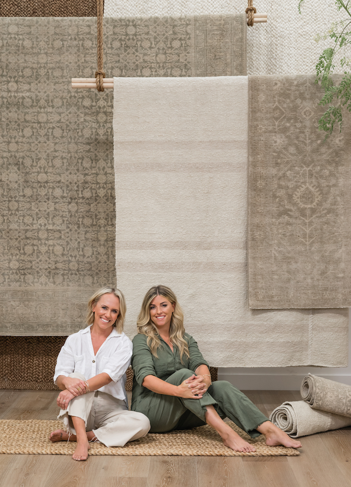 image of pure salt interiors partners Aly Morford Leigh Lincoln sitting with new Momeni rugs