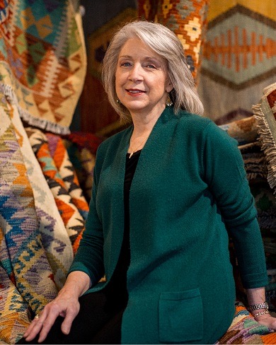 Portrait in front of rug display