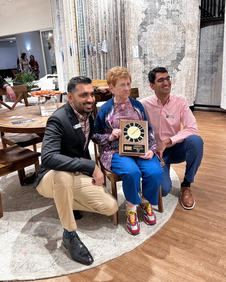 Vaibhav and Vinamra Laddha of LR Home present sales rep Wanda Lanzi with special plaque