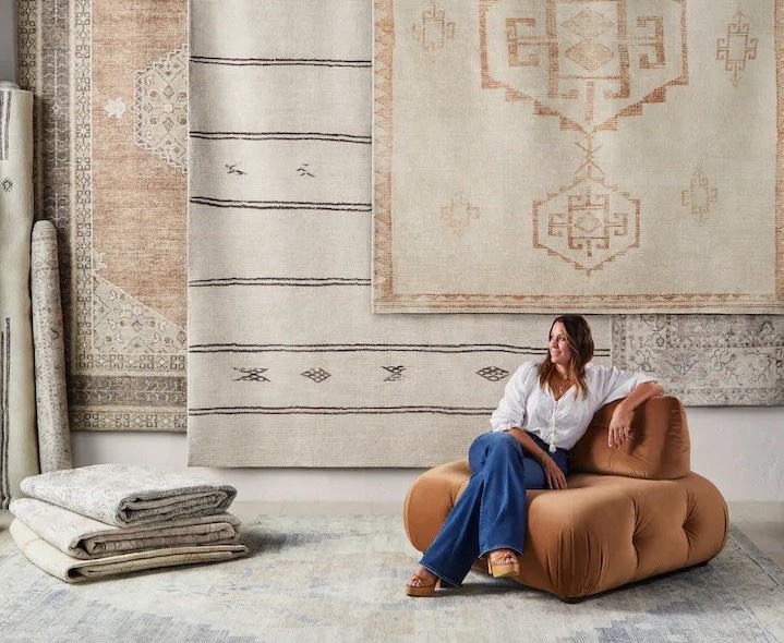Designer Becki Owens pictured with Surya collection rugs