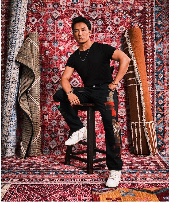 Portrait of fashion designer in display of his new area rugs by rugs use