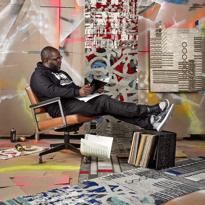 hip hop artist Mike Ford sits with his hip hop inspired collection of carpets for Shaw Contract